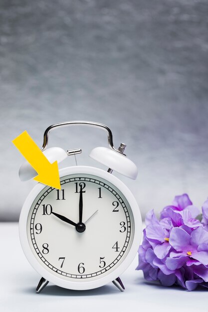 Spring announce on clock with flowers beside