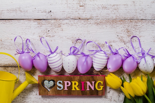 Primavera sfondo con fiori e uova di pasqua in fila