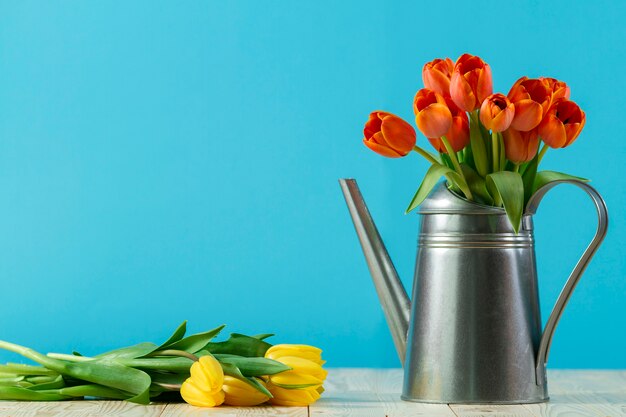 Spring background with flowers and watering can