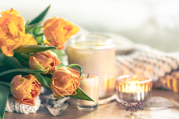 Free photo spring background with yellow tulips candles and knitted element