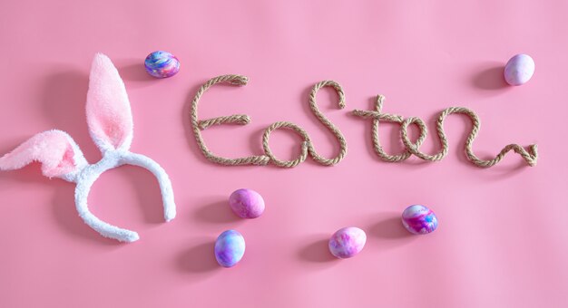 Spring Easter festive.Easter creative inscription on pink with items of Easter decor.