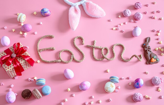 Spring Easter festive.Easter creative inscription on pink with items of Easter decor.