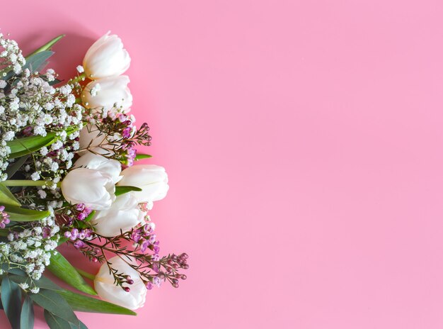 весенняя цветочная композиция на розовой стене