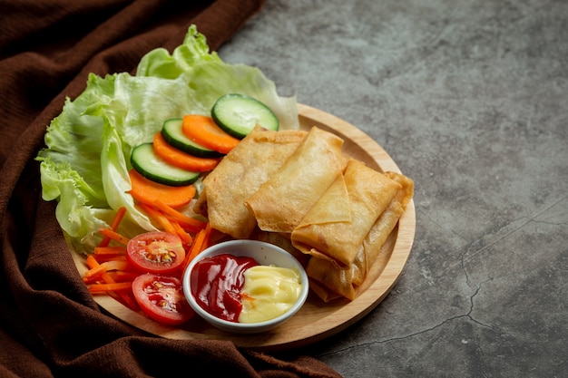 Spring rolls with cheese on dark background