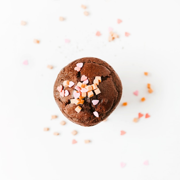 Sprinkle and caramel candies on chocolate cupcake isolated on white background