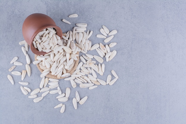 Free photo sprinkled seeds in the overturned bowl on trivet on marble.