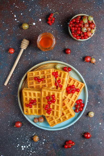 Free photo square belgian waffles with loquat fruits and honey.