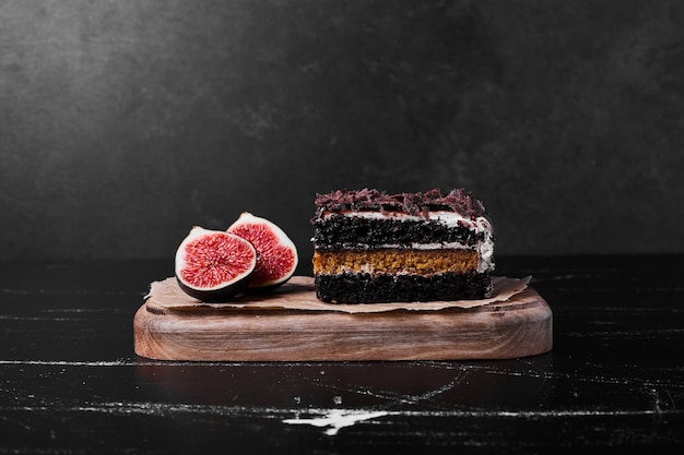 A square slice of chocolate cheesecake on black