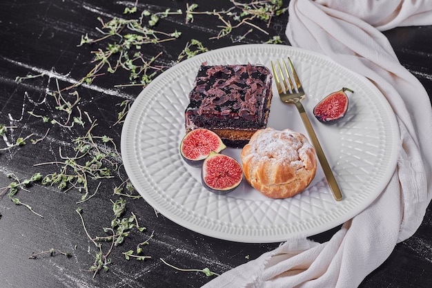 A square slice of chocolate cheesecake with figs and bun.