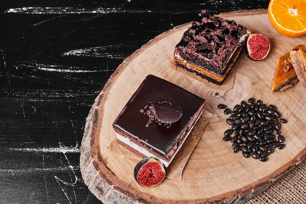 A square slice of chocolate cheesecake on a wooden board.