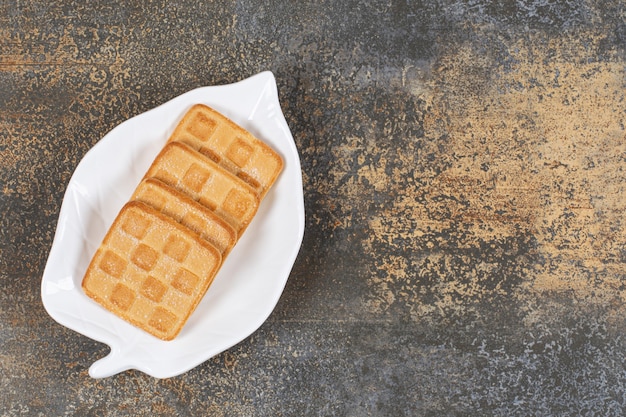 Foto gratuita cracker dolci quadrati su piatto a forma di foglia.