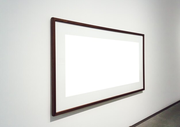 Square white surface with dark frames attached to a wall in a room