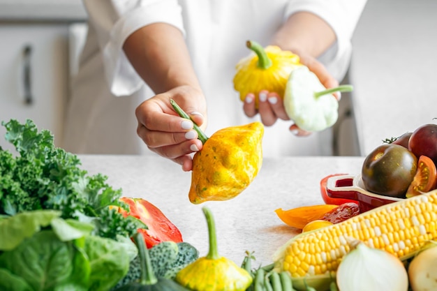 Free photo squash in female hands on the background of the kitchen table