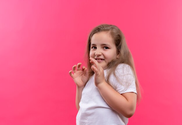 孤立したピンクの背景に白いTシャツを着ているきしむ小さな女子高生