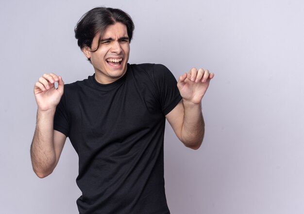 Squeamish looking at side young handsome guy wearing black t-shirt isolated on white wall with copy space