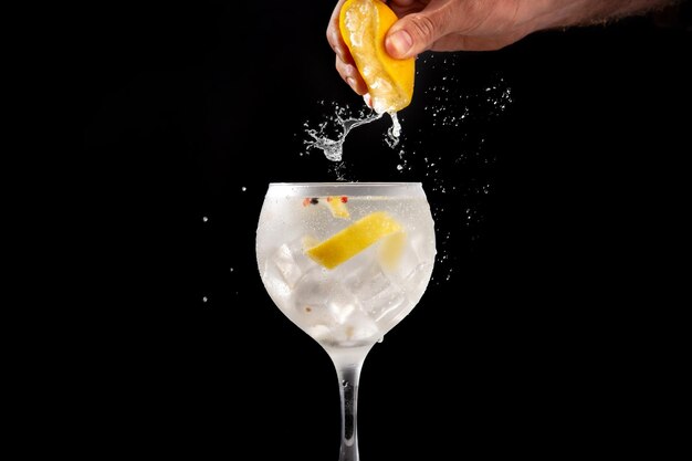 Squeezing a lemon into a glass of gin tonic