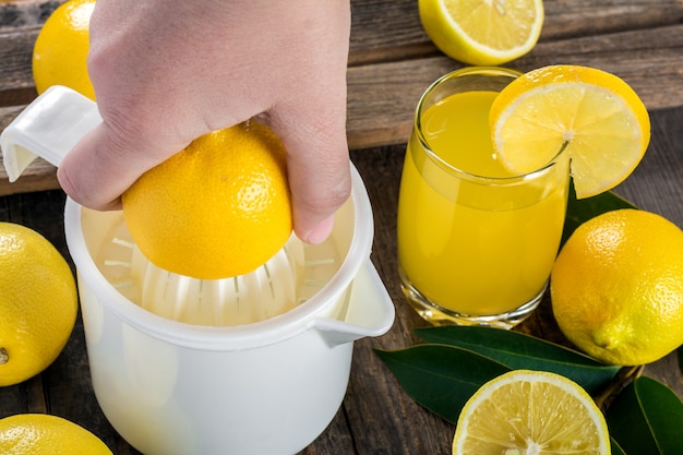Выжимание лимонного сока ручной соковыжималкой Premium Фотографии