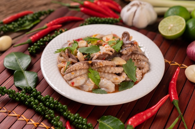 Squid salad with coriander, chopped green onion, garlic and corn on the plate