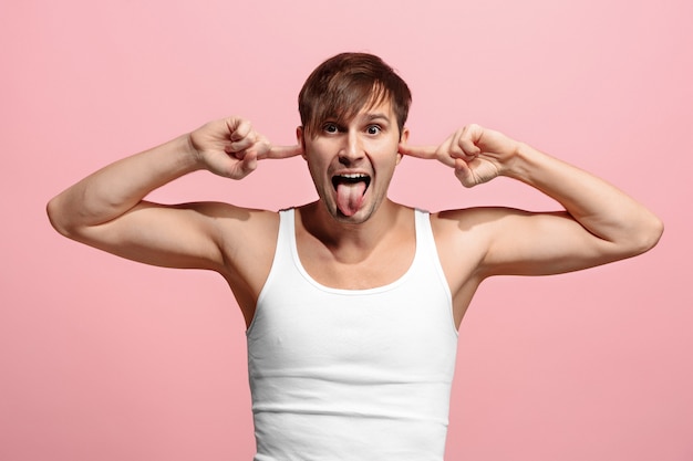 The squint eyed man with weird expression isolated on pink wall