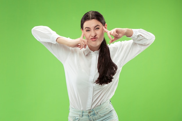 Donna dagli occhi strabici con una strana espressione. bellissimo ritratto femminile a mezzo busto isolato su sfondo verde studio.