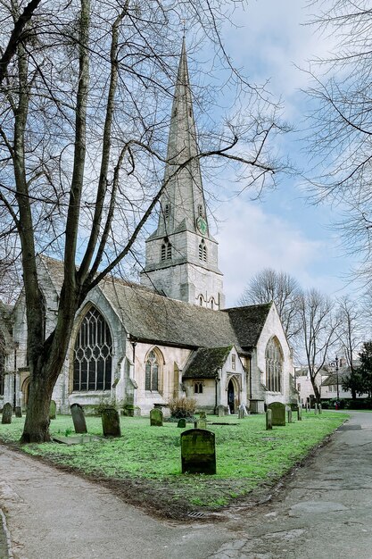 무덤과 나무로 둘러싸인 녹색 잔디밭에있는 세인트 메리 교회