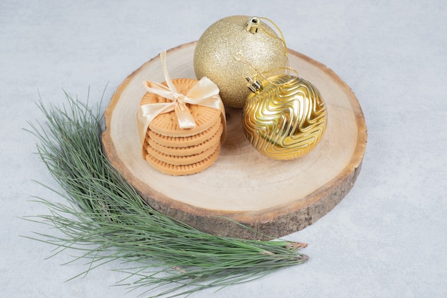 木の板にリボンとクリスマスボールで結ばれたビスケットのスタック。高品質の写真