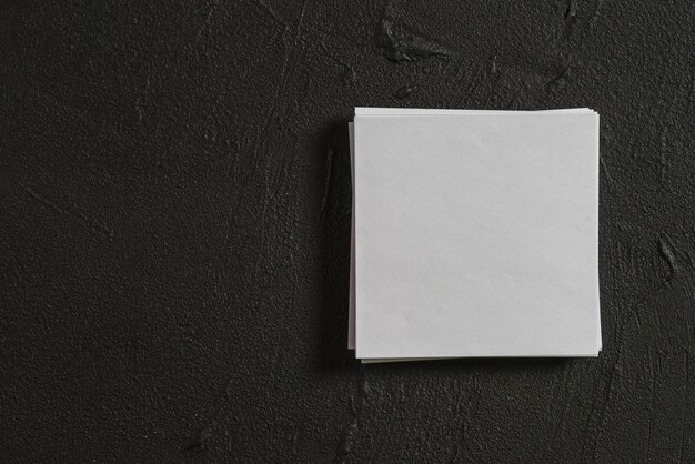 Stack of blank papers on black backdrop