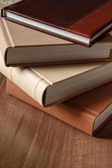 Stack of books in hardcover leather bounds on wooden background