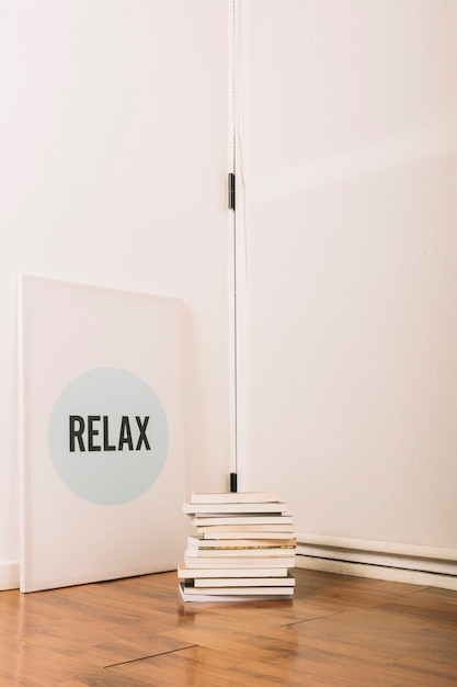 Stack of books lying near inspirational poster