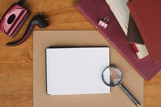 Stack of books and magnifying glass near notebook