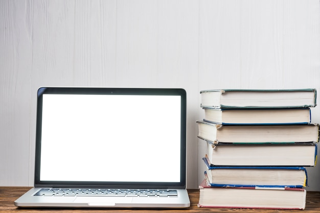 Stack of books near laptop