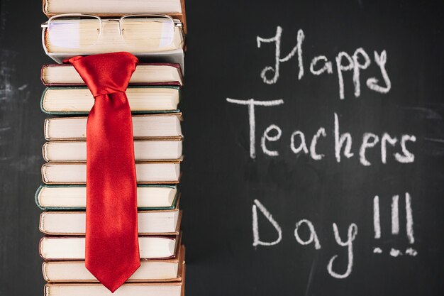 Stack of books with glasses and red tie