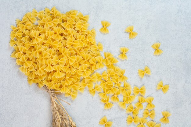 A stack of bow tie pasta, on the marble surface