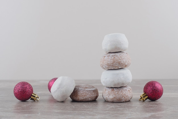 Free photo a stack of cookies and christmas baubles bundled up on marble