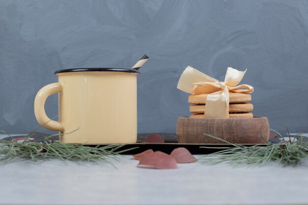 Stack of cookies and cup of tea on marble table. High quality photo