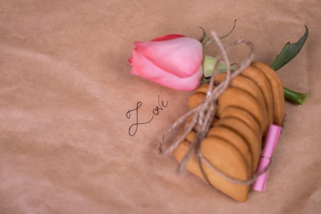 Foto gratuita pila di biscotti a forma di cuore con rosa