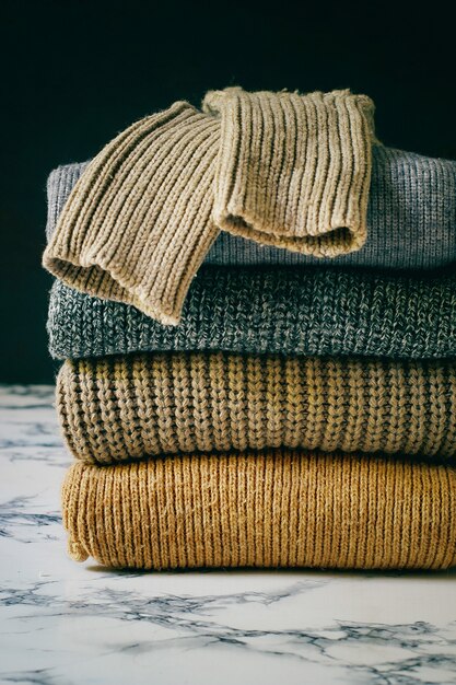 Stack of cozy knitted sweaters. Autumn-winter concept, Knitted wool sweaters. Pile of knitted winter clothes, sweaters, knitwear