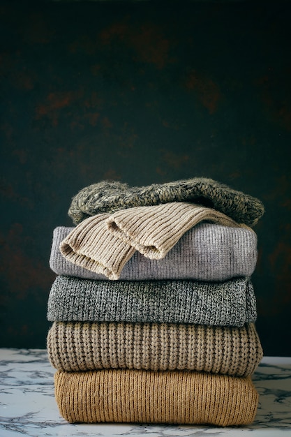 居心地の良いニットセーターのスタック。秋冬コンセプト、ニットウールセーター。ニットの冬服、セーター、ニットの山