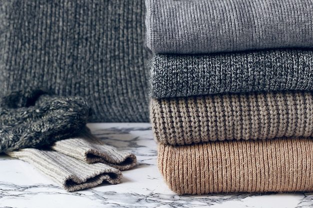 Stack of cozy knitted sweaters. Autumn-winter concept, Knitted wool sweaters. Pile of knitted winter clothes, sweaters, knitwear