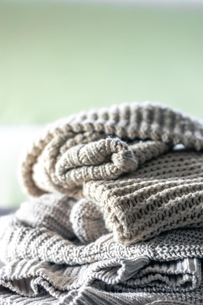 Free photo stack of cozy knitted sweaters on wooden background