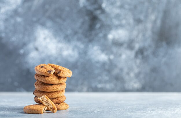 Stack of delicious chocolate chip cookies on marble background