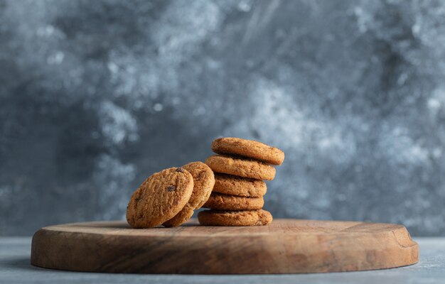 Stack of delicious chocolate chip cookies on wooden board