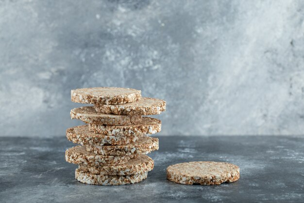 Stack of delicious crispbread on marble surface