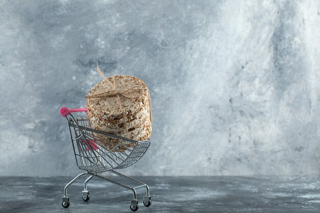 Stack of delicious crispbread in small shopping cart