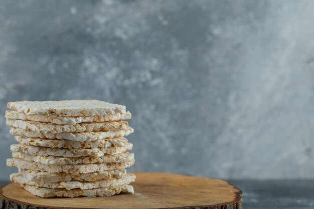 Stack of delicious crispbread on wood piece