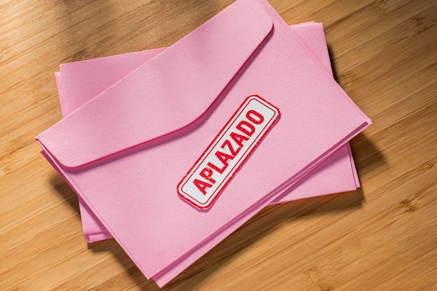 Stack of envelope with postponed message on desk