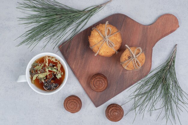 Free photo stack of festive biscuits and cup of tea on gray table. high quality photo