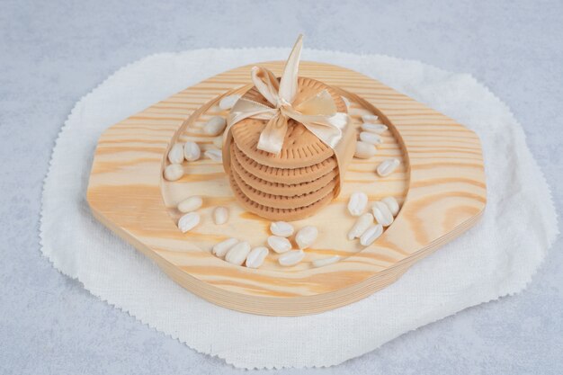 Stack of festive biscuits and peanuts on wooden plate. High quality photo