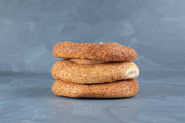 Stack of freshly baked bagels on marble background. 