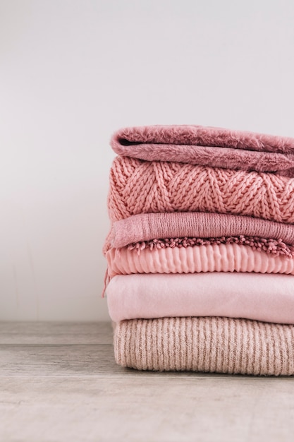 Stack of knitted sweaters on floor